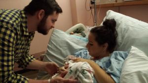 Tired mommy and daddy looking at their little treasure